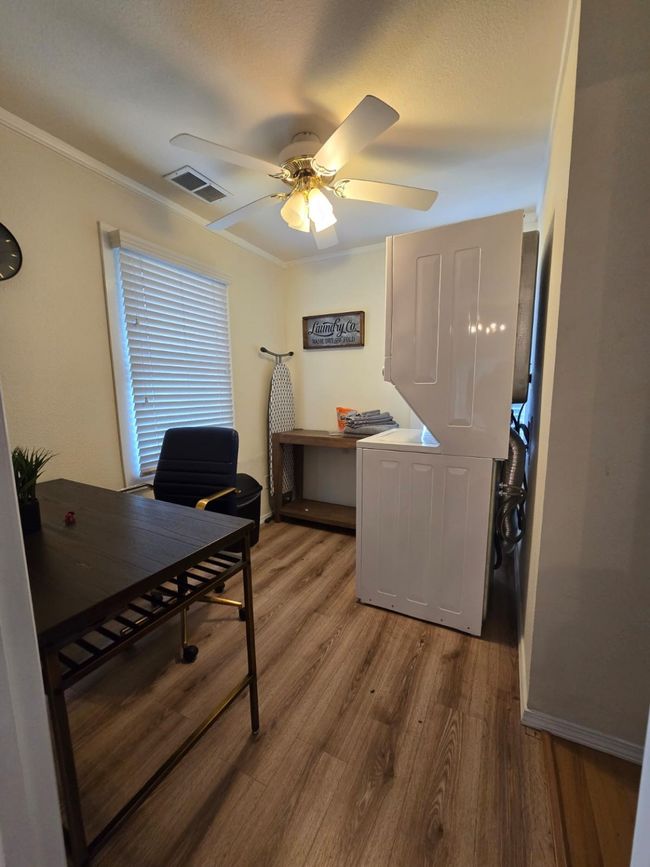 Office area with light wood-type flooring, ceiling fan, and crown molding | Image 26