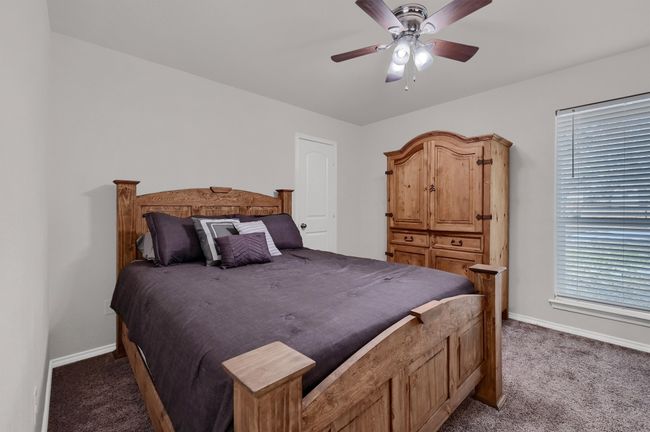 Bedroom with dark colored carpet and a ceiling fan | Image 22