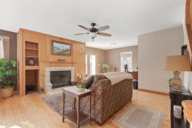 Hardwood floors throughout most of main level. This spacious LR has loads of natural light and a wood-burning fireplace for those cold winter nights. | Image 9