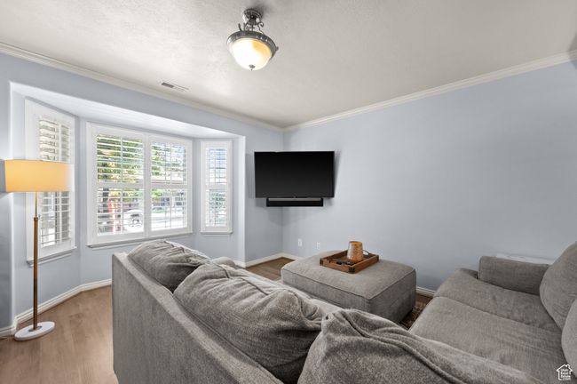 Living room with ornamental molding and wood finished floors | Image 4