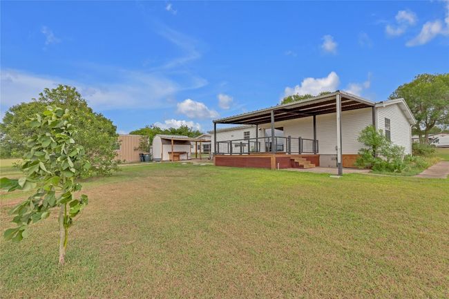 View of grassy yard with a storage unit | Image 5