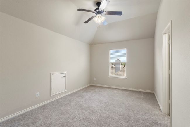 Carpeted empty room with a ceiling fan, vaulted ceiling, and baseboards | Image 24