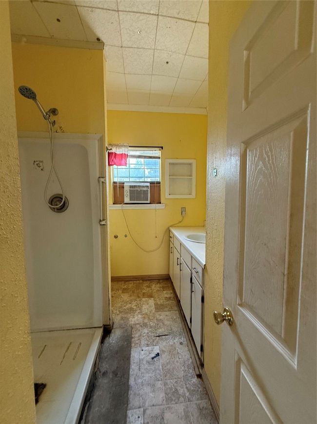 Full bath featuring a stall shower, vanity, cooling unit, stone finish flooring, and baseboards | Image 13