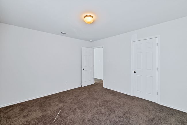 Unfurnished bedroom with dark colored carpet and baseboards | Image 23