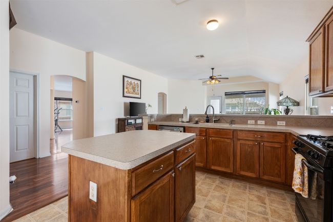 Kitchen with visible vents, a sink, gas stove, arched walkways, and ceiling fan | Image 18