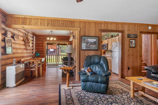 Living room featuring light wood-style flooring, log walls, and wooden walls | Image 35