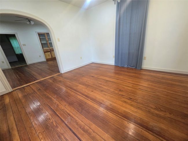 Empty room with hardwood / wood-style floors, arched walkways, and ceiling fan | Image 25