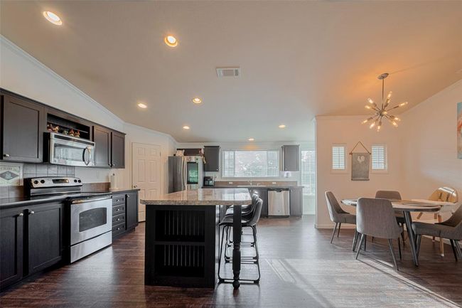 The overall interior design emphasizes functionality and style, making it an inviting area for cooking and dining. | Image 18