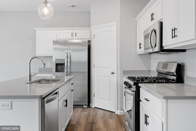 (Photo of previously finished home) Stylish, durable countertops paired with modern appliances and sleek white cabinetry. | Image 9