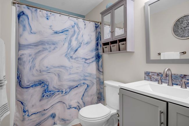 Full bathroom featuring vanity, toilet, and a shower with shower curtain | Image 26