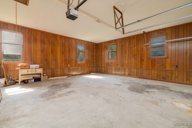 Garage featuring a garage door opener and wooden walls | Image 22