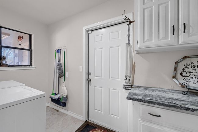 Washroom with cabinet space, washer and clothes dryer, and light tile patterned floors | Image 14