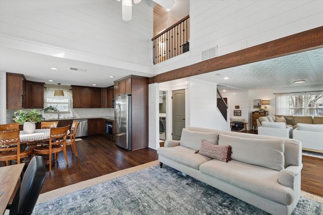 Living room with healthy amount of natural light, washer / clothes dryer, dark wood-style flooring, and a towering ceiling | Image 13