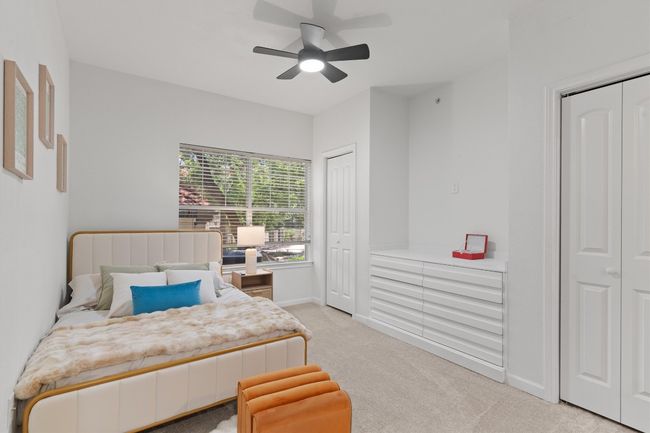 Bedroom featuring multiple closets, light colored carpet, baseboards, and a ceiling fan | Image 10