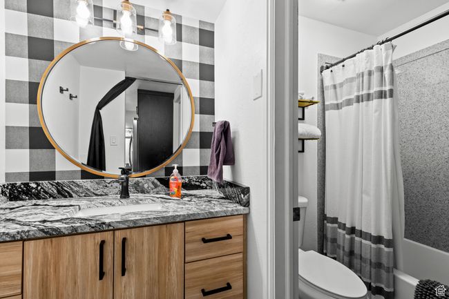Full bathroom featuring vanity, shower / bathtub combination with curtain, and toilet | Image 12