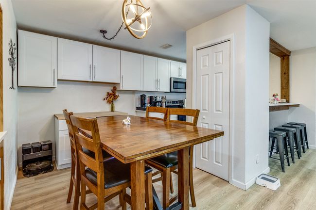 Dining room featuring light wood-style floors, visible vents, and a notable chandelier | Image 11