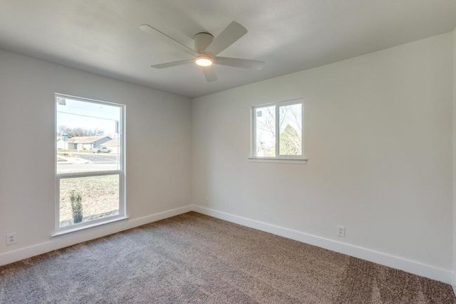 Spare room with a ceiling fan, carpet flooring, and baseboards | Image 19