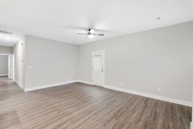 Spare room featuring a ceiling fan, wood finished floors, and baseboards | Image 9