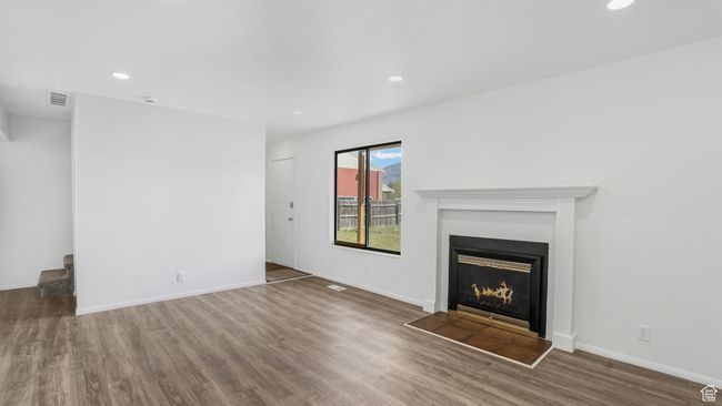 Unfurnished living room featuring wood finished floors, recessed lighting, and visible vents | Image 4