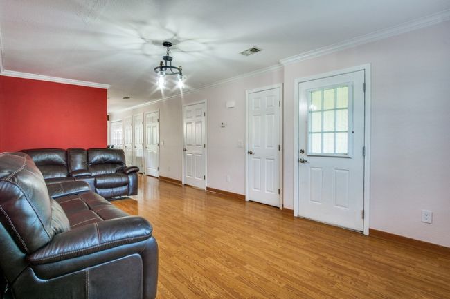 Living area featuring light wood-style flooring, healthy amount of natural light, and ornamental molding | Image 7
