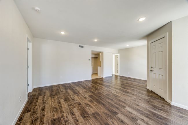view from living room to kitchen and bedrooms on each side | Image 5