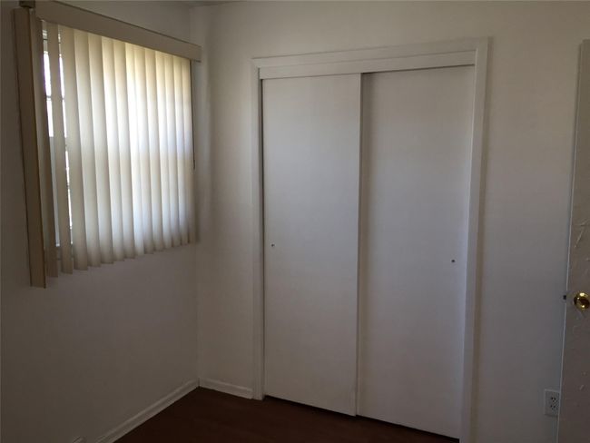 Unfurnished bedroom with dark wood-type flooring and a closet | Image 31