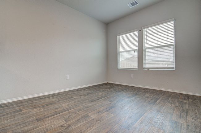 Unfurnished room featuring dark wood-type flooring, visible vents, and baseboards | Image 12