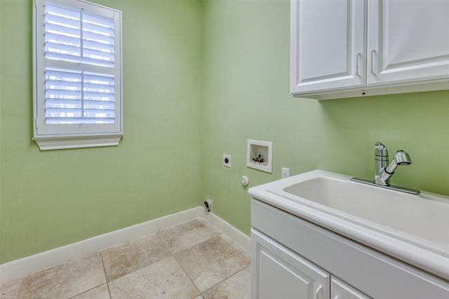Clothes washing area featuring hookup for a washing machine, baseboards, a sink, electric dryer hookup, and cabinet space | Image 18