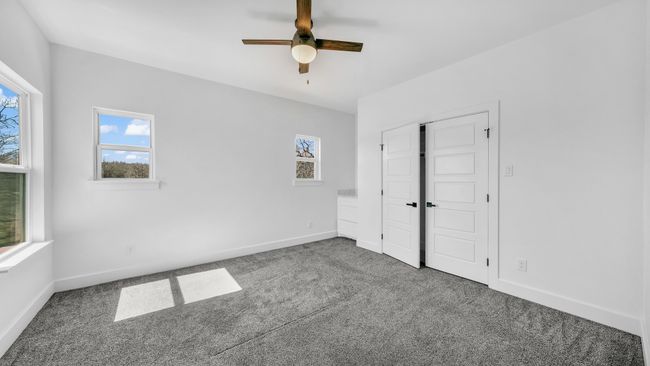 Unfurnished bedroom featuring multiple windows, carpet, and baseboards | Image 31
