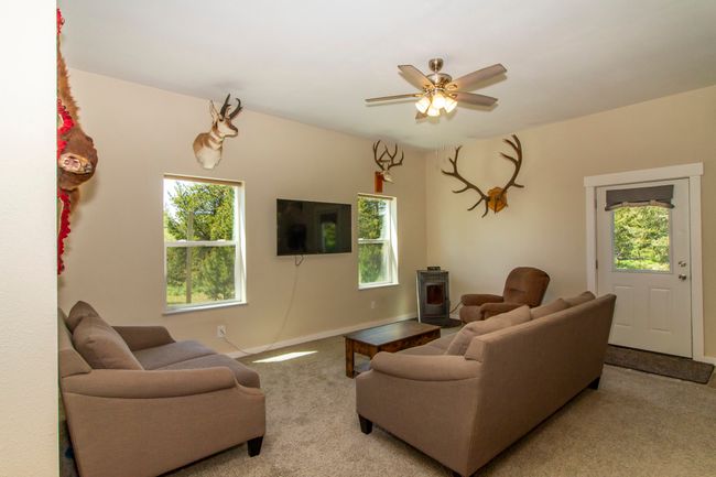Carpeted living area with a pellet stove, and ceiling fan | Image 4