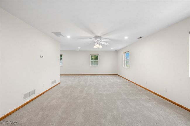 Empty room with ceiling fan and light colored carpet | Image 21
