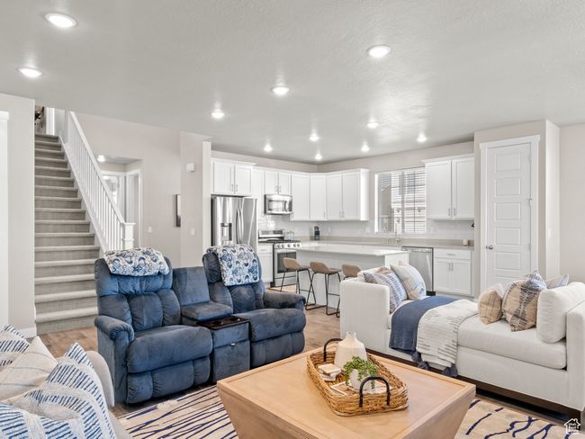 Living area with light wood-style flooring, stairway, and recessed lighting | Image 9