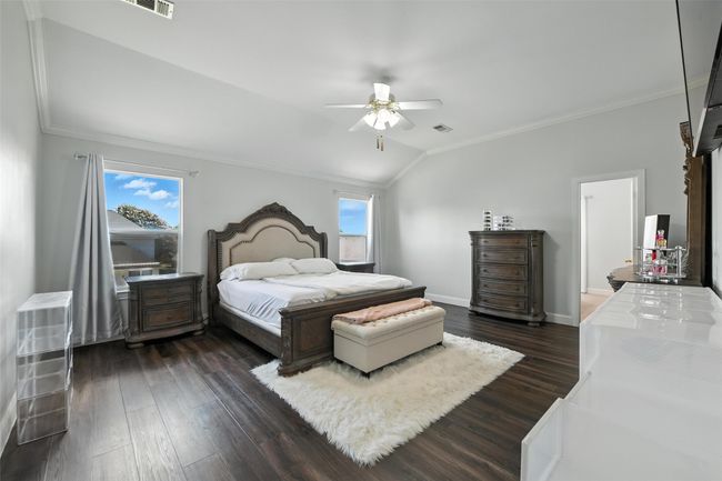 Bedroom with ornamental molding, multiple windows, dark wood-type flooring, vaulted ceiling, and ceiling fan | Image 22