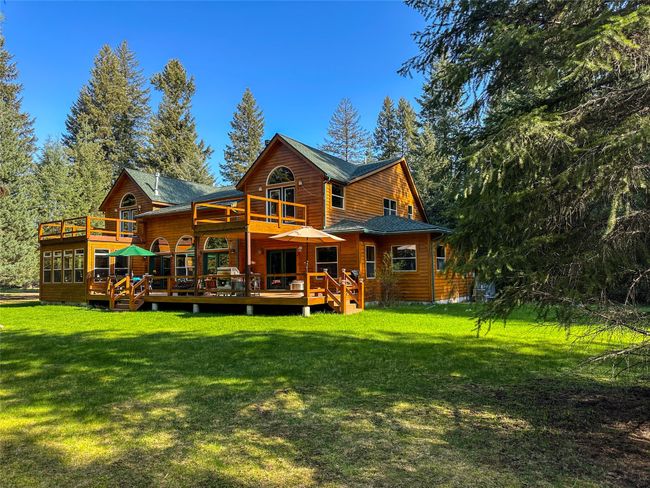 Rear view of house with a wooden deck and a yard | Image 48