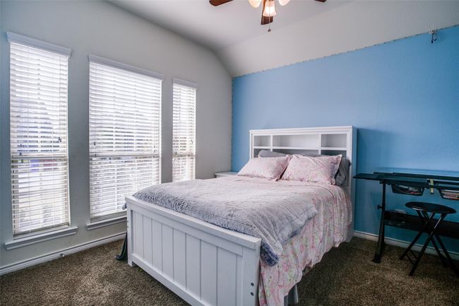 Bedroom with vaulted ceiling, dark carpet, and ceiling fan | Image 16