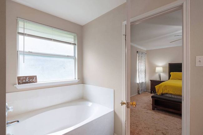 Full bath with healthy amount of natural light, a bath, ensuite bath, and ornamental molding | Image 19