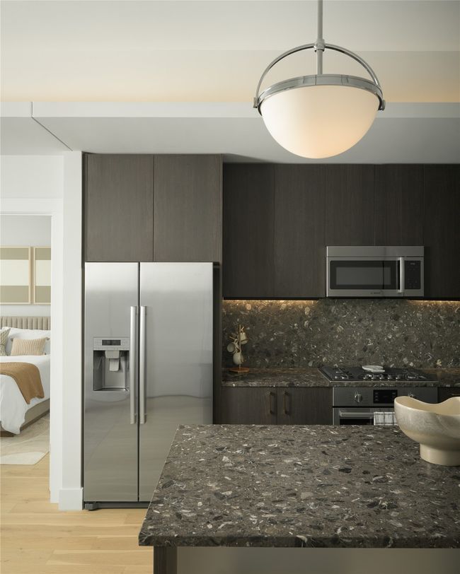 Kitchen with stainless steel appliances, decorative backsplash, light wood finished floors, dark stone counters, and modern cabinets | Image 15