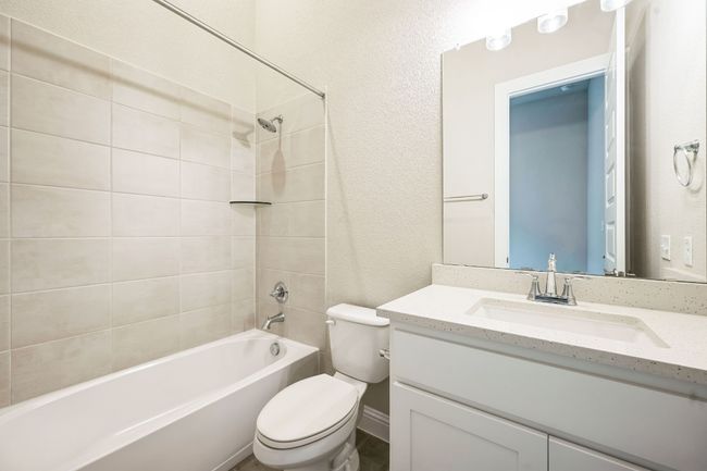 Full bath with a textured wall, vanity, shower / tub combination, and toilet | Image 22