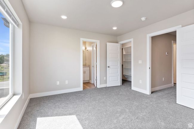 Unfurnished bedroom with light colored carpet, a spacious closet, recessed lighting, and baseboards | Image 7