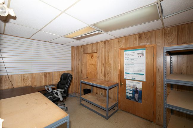 Office area featuring a drop ceiling and wood walls | Image 20