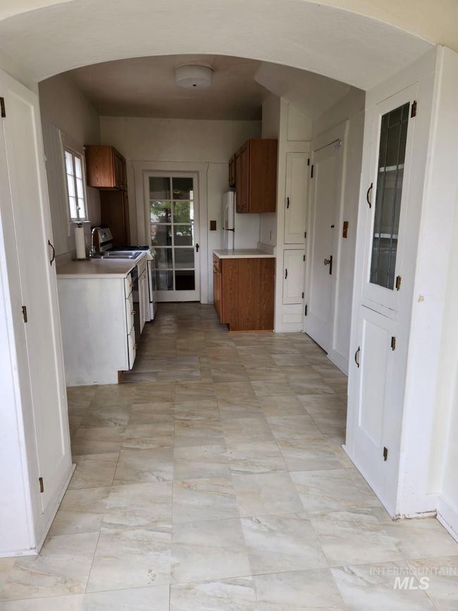 Kitchen with light countertops, brown cabinets, and white appliances | Image 8