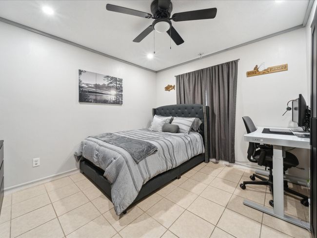 Bedroom with light tile patterned floors, an office area, ceiling fan, and recessed lighting | Image 11