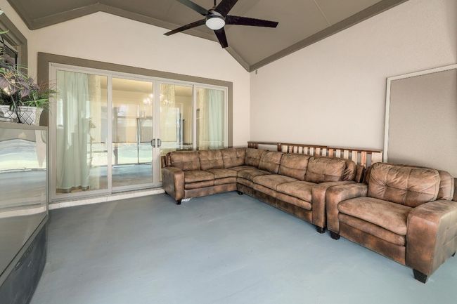 Living area with finished concrete flooring, vaulted ceiling, and a ceiling fan | Image 34