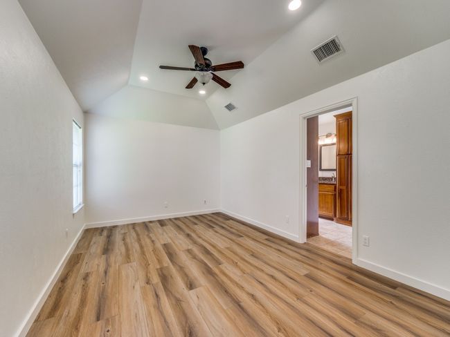 Spare room with ceiling fan, light wood finished floors, lofted ceiling, and recessed lighting | Image 12
