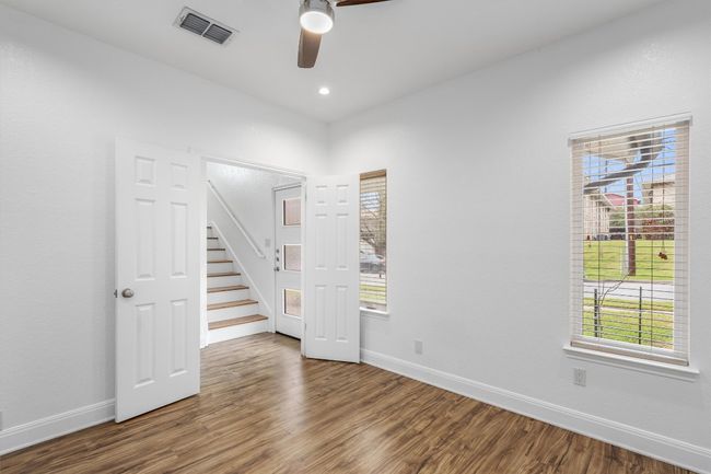 Unfurnished room with a ceiling fan, visible vents, plenty of natural light, and wood finished floors | Image 12