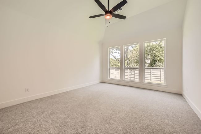 Spare room with light colored carpet, baseboards, ceiling fan, and high vaulted ceiling | Image 17