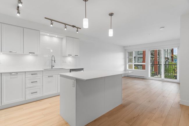 Kitchen with a sink, a baseboard heating unit, white cabinetry, and light countertops | Image 5