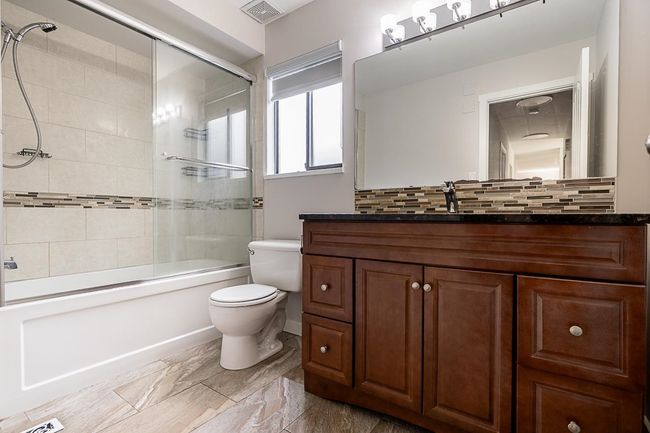 Bathroom featuring vanity, combined bath / shower with glass door, and marble finish floors | Image 20
