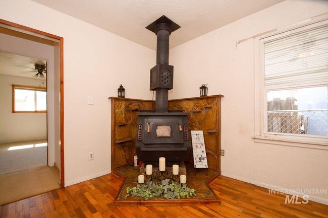 Detailed view of a wood stove, wood finished floors, and ceiling fan | Image 21