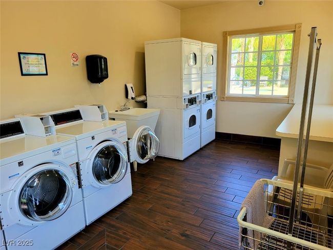 Common laundry area with stacked washing maching and dryer, separate washer and dryer, and dark wood-style flooring | Image 19